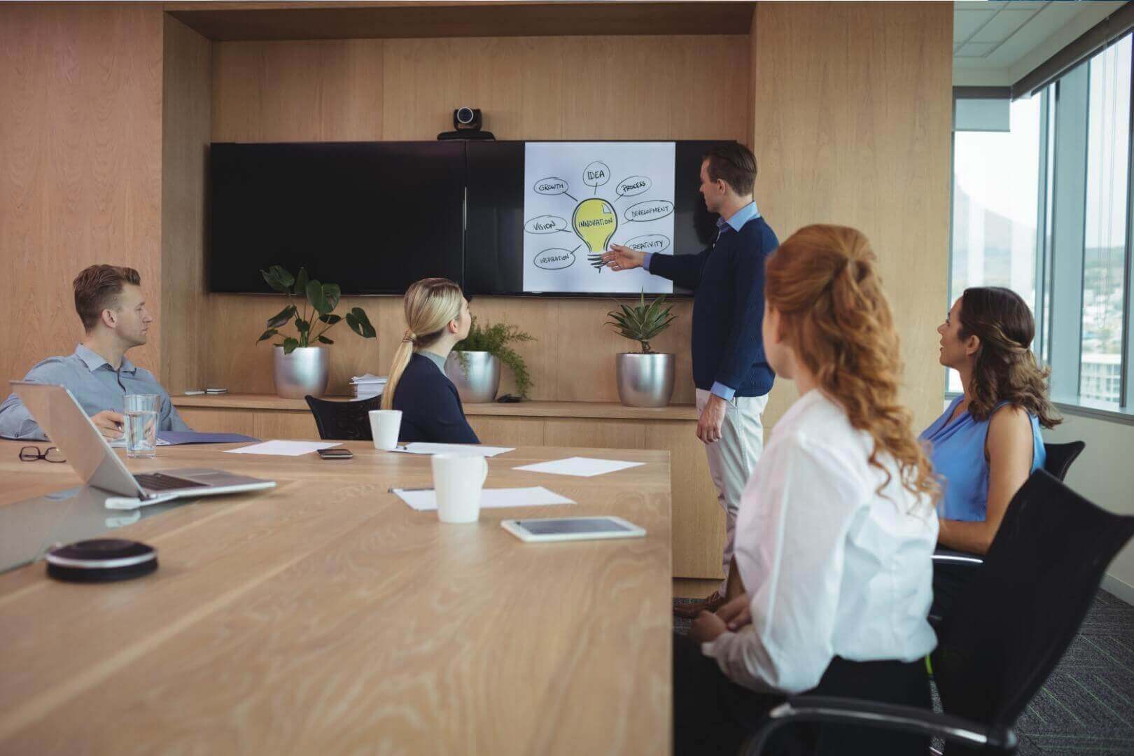Team meeting discussing organizational psychology strategies in modern conference room.